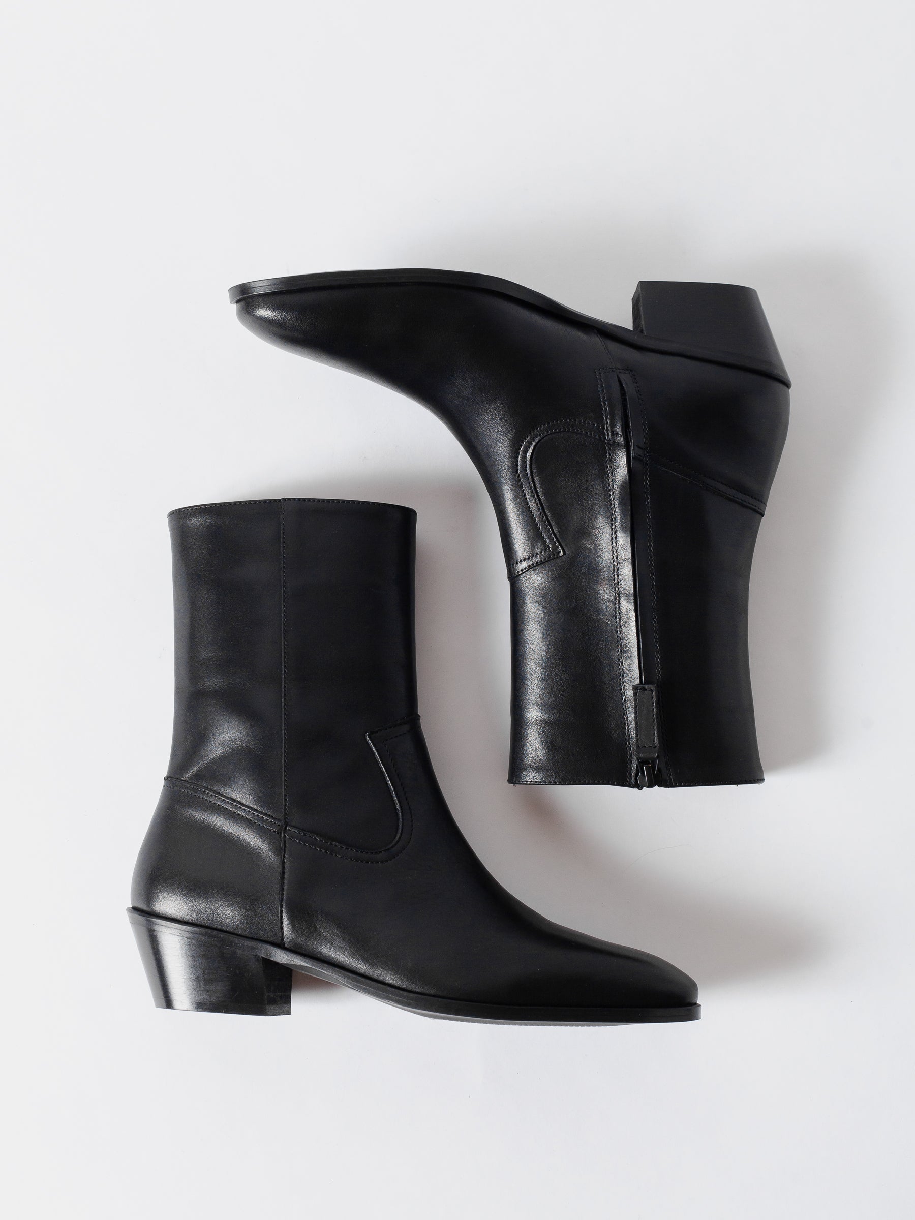 Pair of black leather ankle boots on a white background