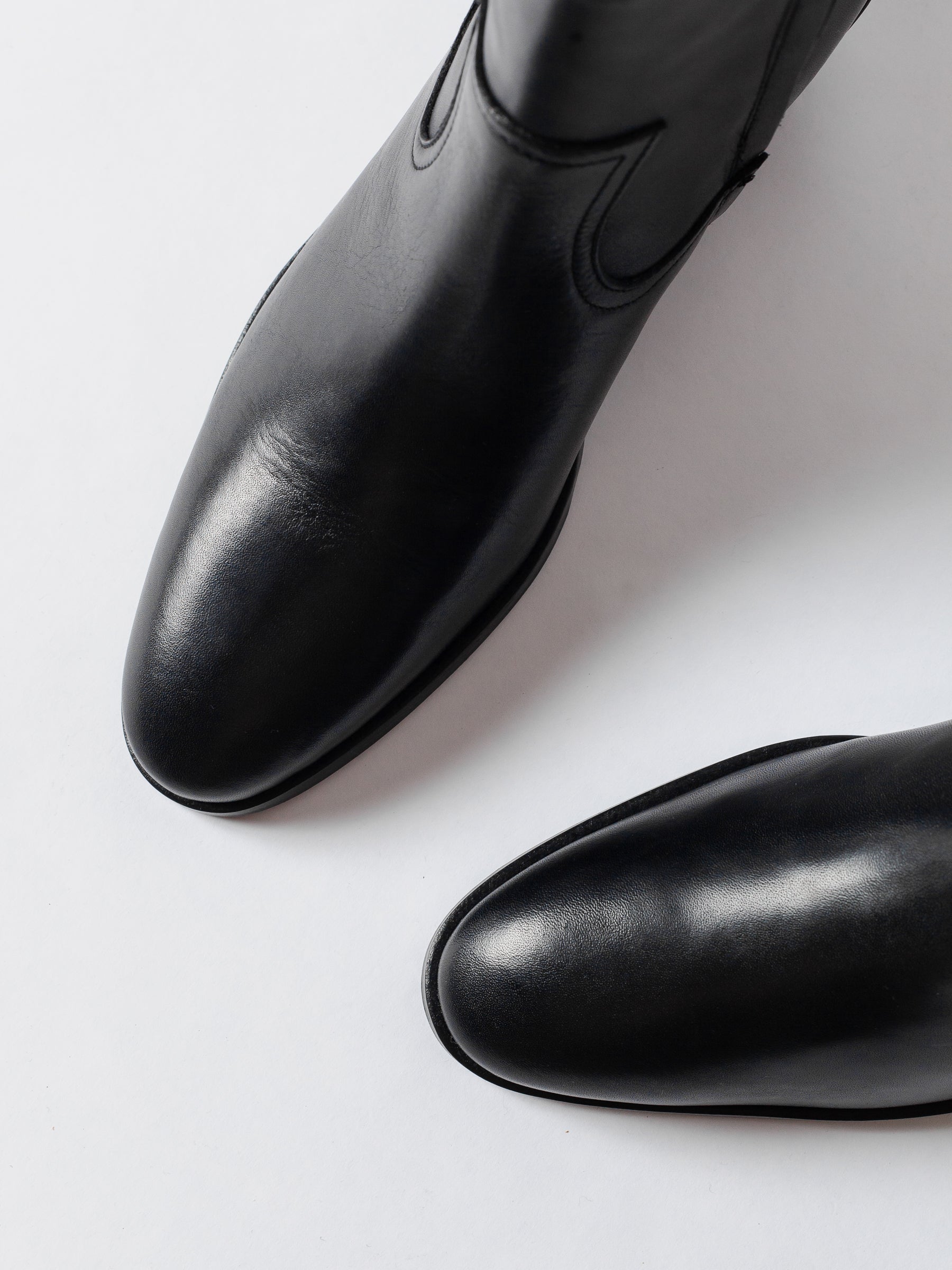 Two black leather shoes on a white background