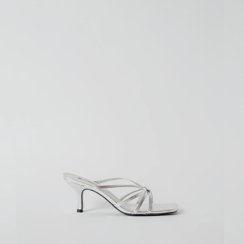 Clear high-heeled shoe on a light gray background