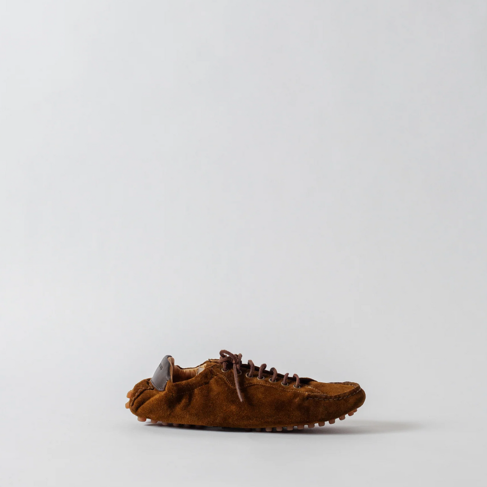 Brown suede shoe on a light gray background